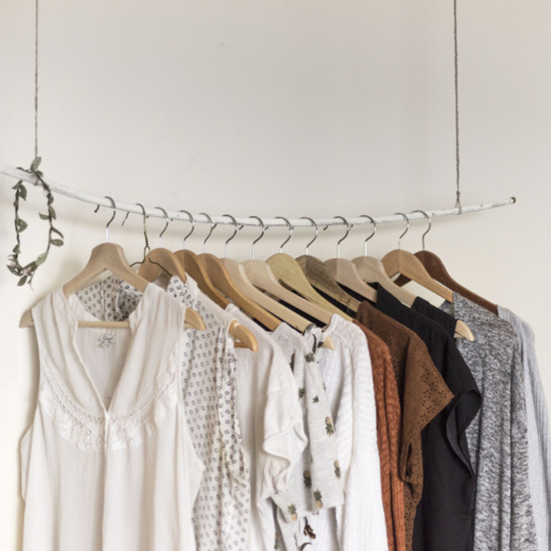 Clothing on wooden hangers on rod