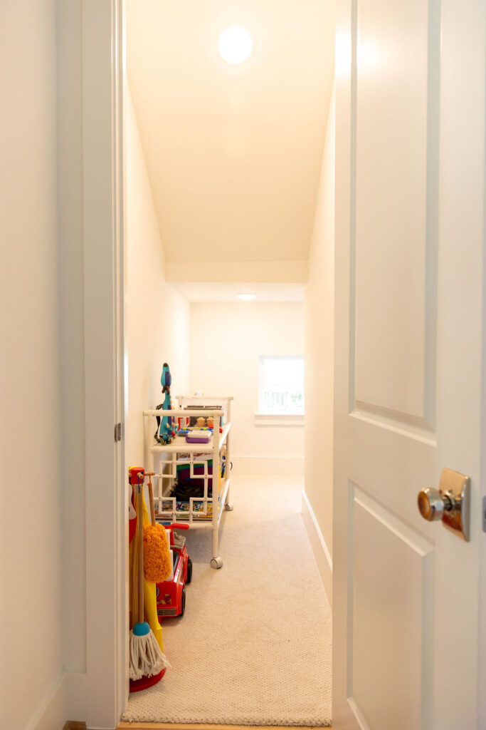 Organized playroom with labeled bins and open floor space for kids’ activities.